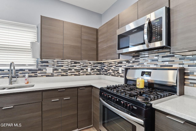 kitchen with tasteful backsplash, stainless steel appliances, sink, and dark brown cabinets