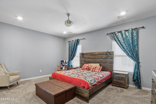 bedroom featuring light carpet, multiple windows, and ceiling fan