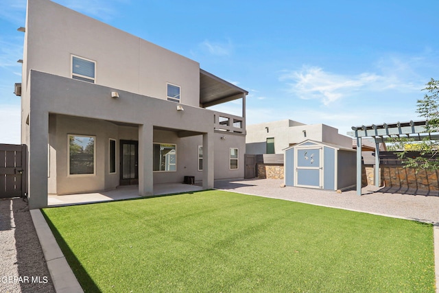 rear view of property with a patio, a pergola, a yard, and a storage unit