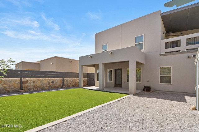 back of house with a patio area and a lawn