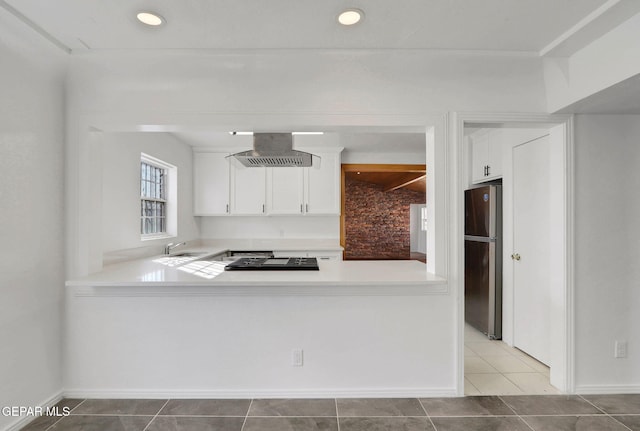 kitchen featuring tile patterned floors, exhaust hood, stainless steel refrigerator, kitchen peninsula, and white cabinets