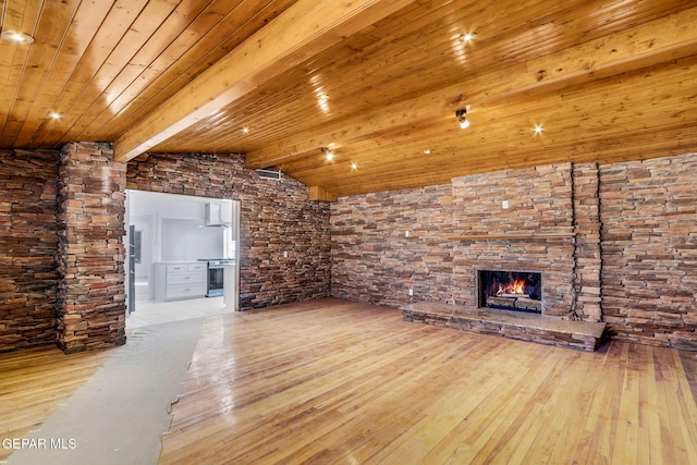 unfurnished living room featuring vaulted ceiling with beams, a fireplace, light hardwood / wood-style floors, and wooden ceiling