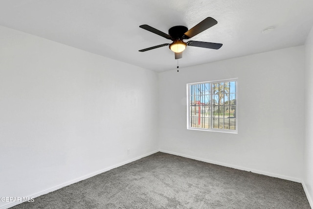 empty room with dark carpet and ceiling fan