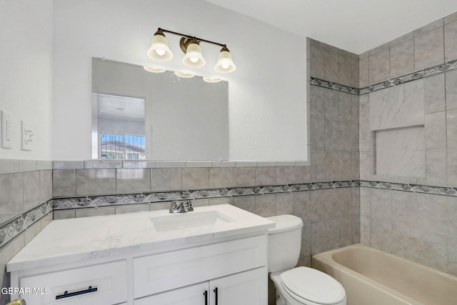 full bathroom featuring tile walls, vanity, tiled shower / bath combo, and toilet