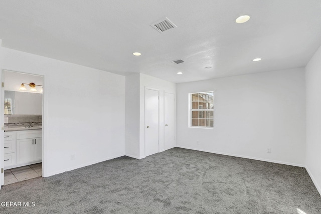 spare room featuring sink and carpet floors