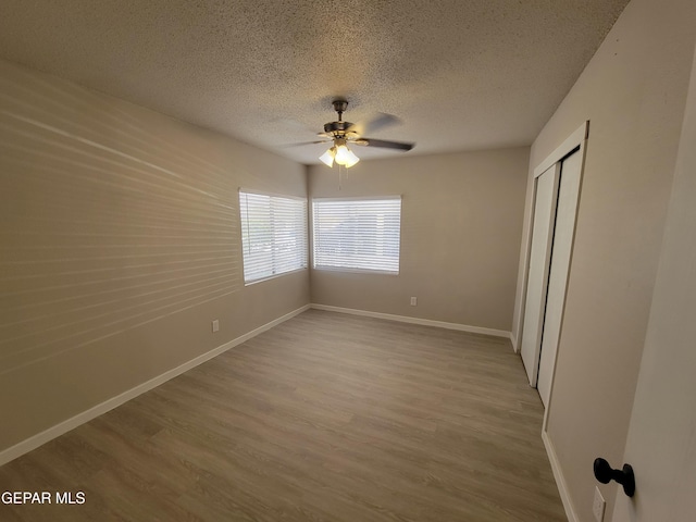 spare room with ceiling fan, hardwood / wood-style floors, and a textured ceiling