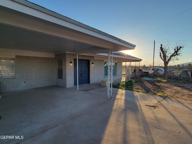 patio terrace at dusk featuring a carport