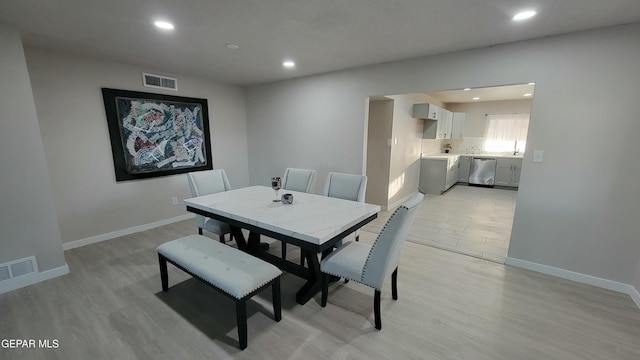 dining space with sink and light hardwood / wood-style flooring