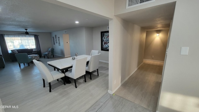 dining space with ceiling fan and light hardwood / wood-style flooring