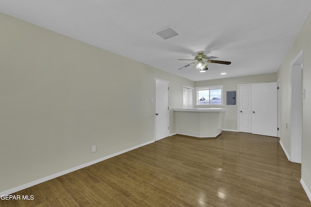 spare room featuring electric panel, dark hardwood / wood-style floors, and ceiling fan