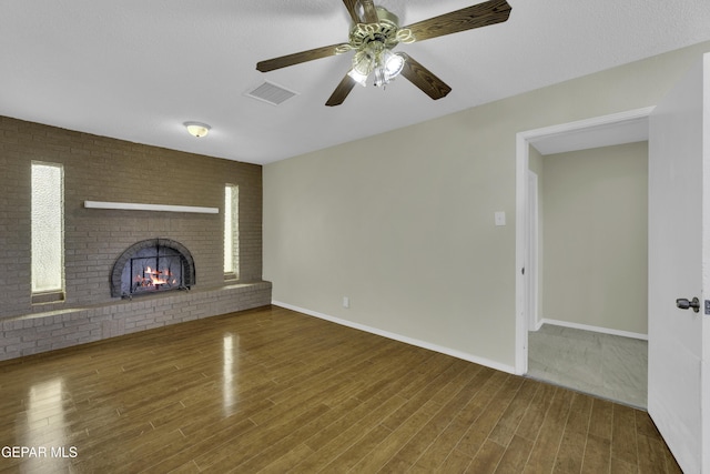 unfurnished living room featuring hardwood / wood-style floors, a fireplace, and ceiling fan