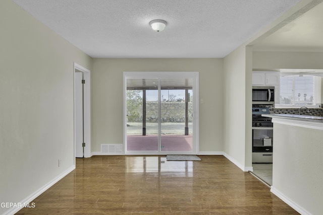 interior space featuring hardwood / wood-style floors, sink, and a textured ceiling