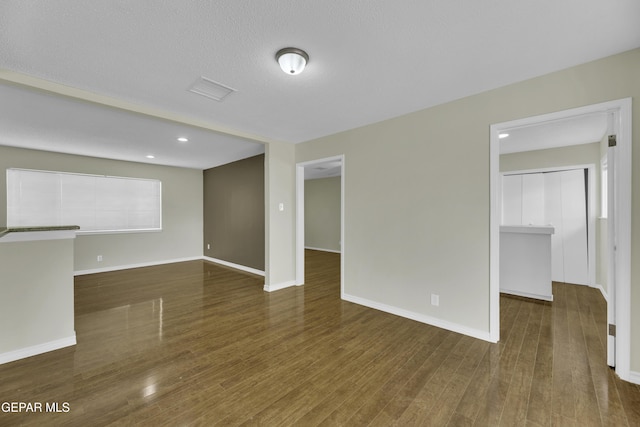 unfurnished room featuring dark hardwood / wood-style flooring and a textured ceiling