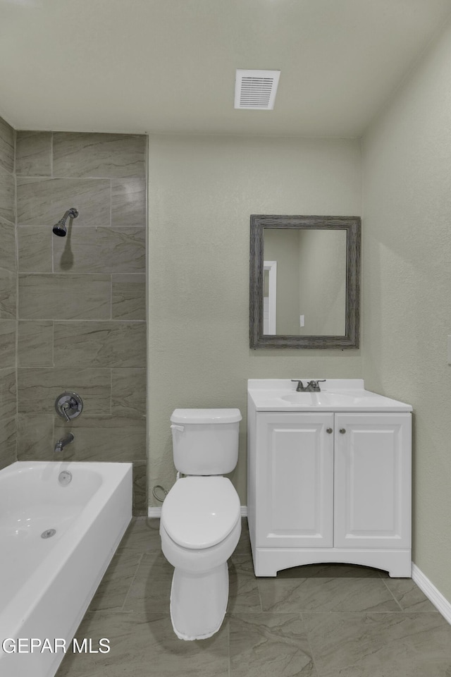 full bathroom with tiled shower / bath, vanity, and toilet