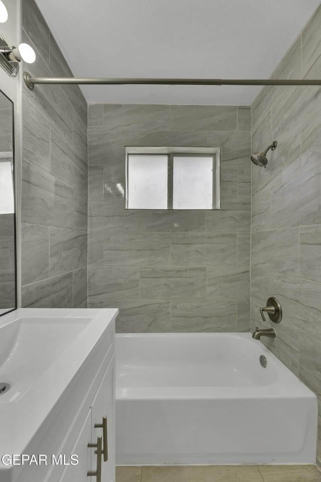 bathroom with tiled shower / bath combo and vanity