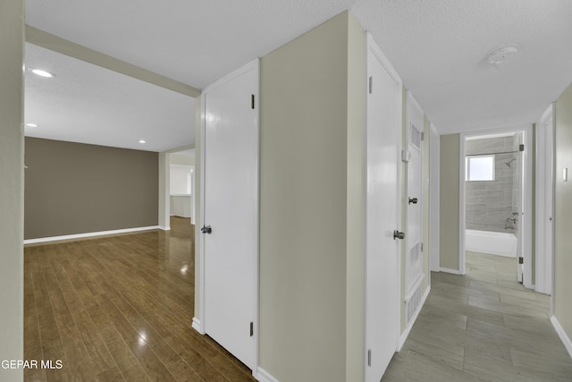 hallway with wood-type flooring and a textured ceiling