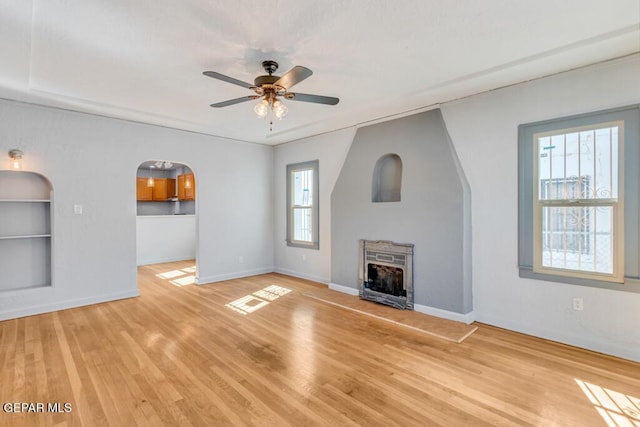 unfurnished living room with ceiling fan, light hardwood / wood-style floors, and a wealth of natural light