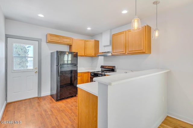 kitchen featuring pendant lighting, black fridge, light brown cabinetry, stainless steel range with gas cooktop, and kitchen peninsula