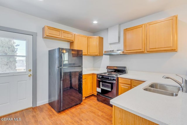 kitchen with light wood-type flooring, sink, light brown cabinets, and black appliances