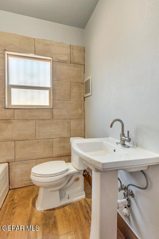 bathroom with hardwood / wood-style flooring and toilet