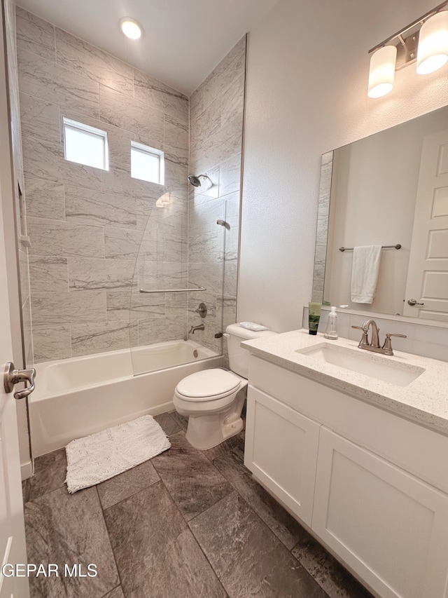 full bathroom featuring vanity, toilet, and tiled shower / bath