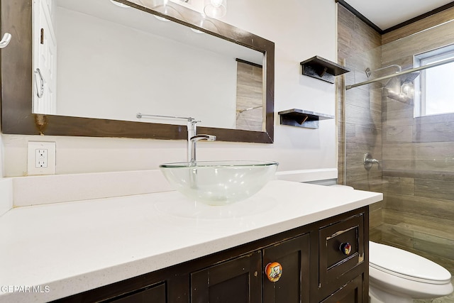 bathroom featuring vanity, toilet, and tiled shower