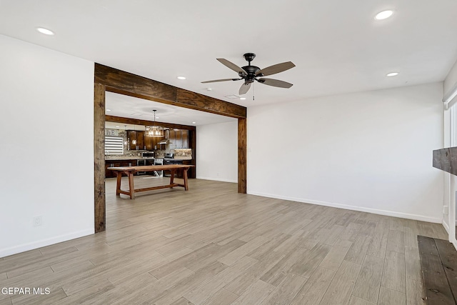 living room with ceiling fan, beamed ceiling, and light wood-type flooring