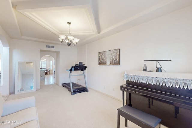 interior space with carpet floors, an inviting chandelier, and a tray ceiling