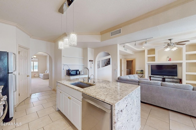 kitchen featuring sink, an island with sink, built in features, stainless steel appliances, and white cabinets