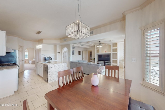 tiled dining room featuring sink, built in shelves, ceiling fan with notable chandelier, and ornamental molding