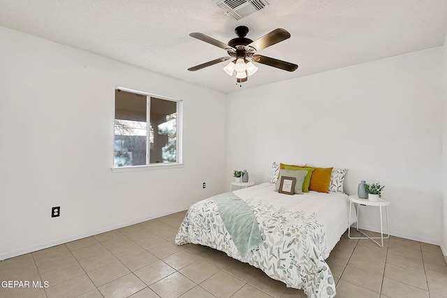 bedroom featuring light tile patterned floors, a textured ceiling, and ceiling fan