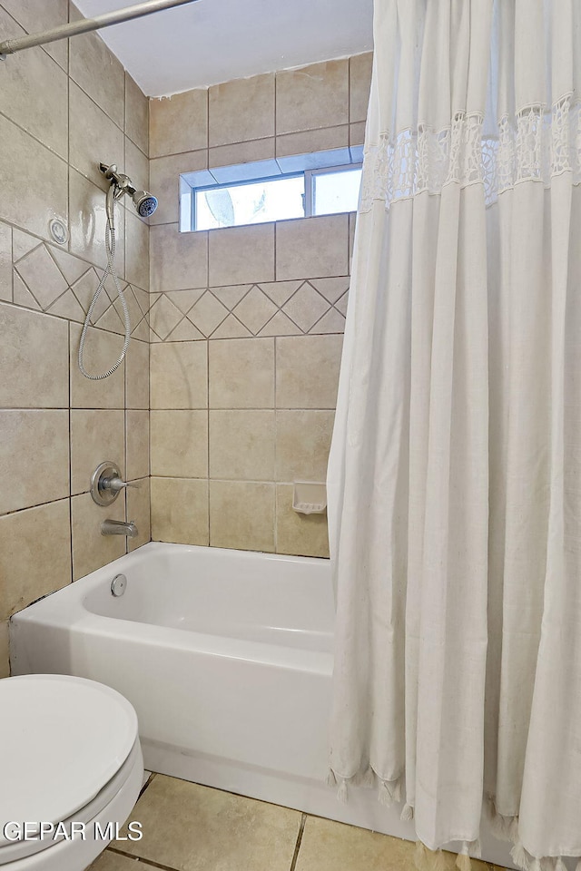 bathroom featuring tile patterned floors, toilet, and shower / bath combo with shower curtain