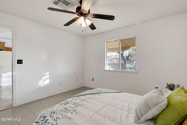 tiled bedroom featuring ceiling fan, fridge, and a textured ceiling