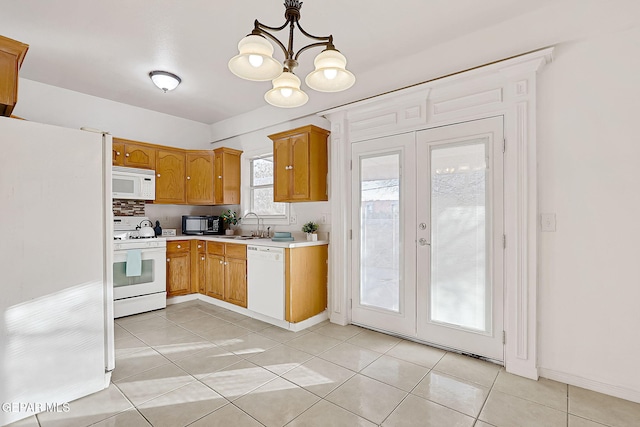 kitchen with french doors, light tile patterned flooring, sink, pendant lighting, and white appliances