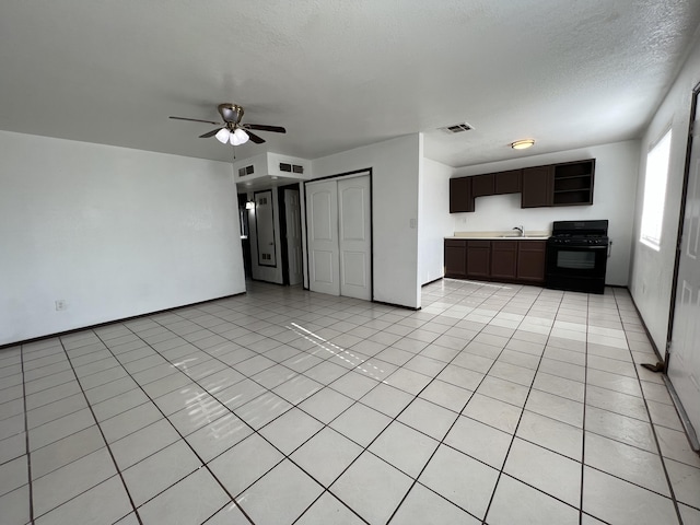 unfurnished living room featuring light tile patterned floors, sink, a textured ceiling, and ceiling fan