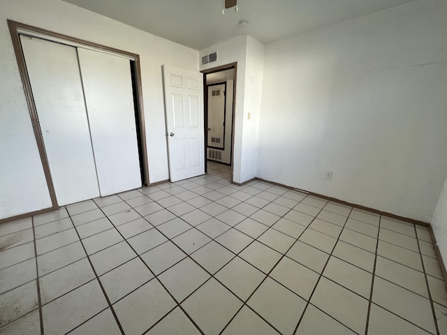 unfurnished bedroom with light tile patterned floors and a closet