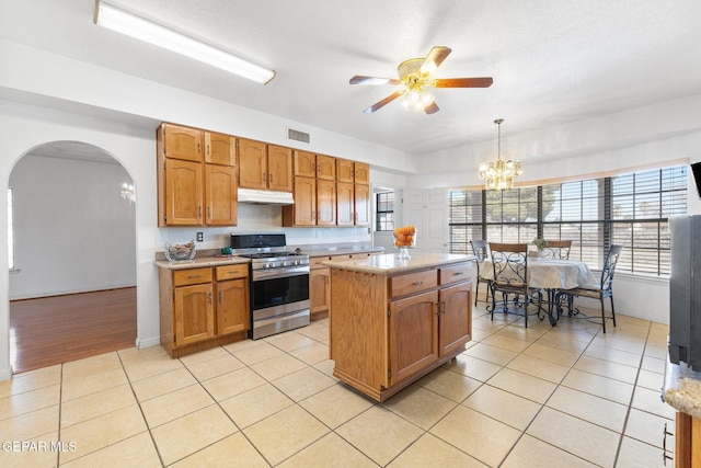 kitchen featuring a kitchen island, light tile patterned flooring, stainless steel range with gas cooktop, and pendant lighting