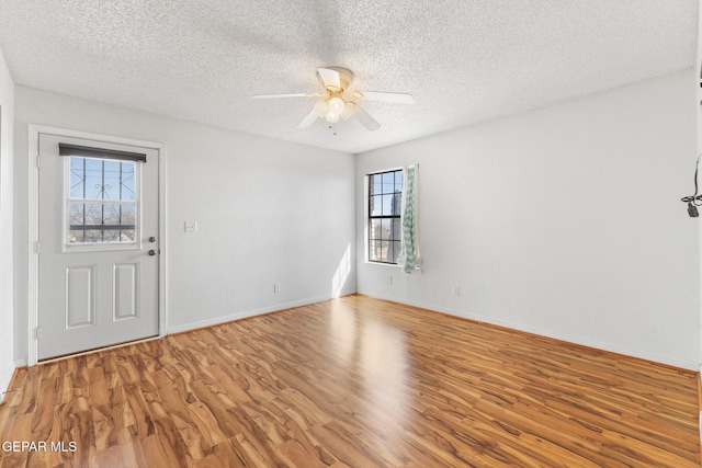 empty room with hardwood / wood-style flooring, a textured ceiling, and ceiling fan