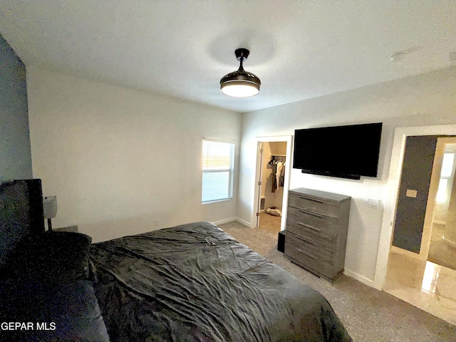 carpeted bedroom featuring a walk in closet