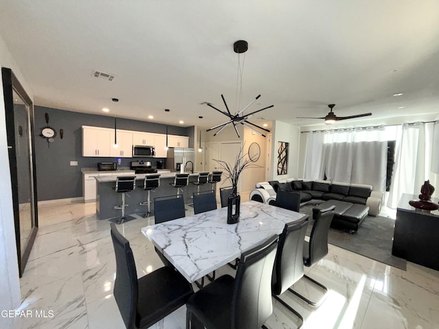 dining area with ceiling fan with notable chandelier