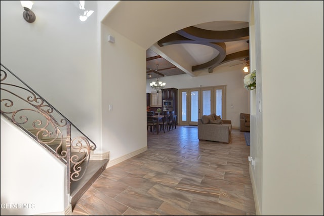 foyer with an inviting chandelier, french doors, and beamed ceiling