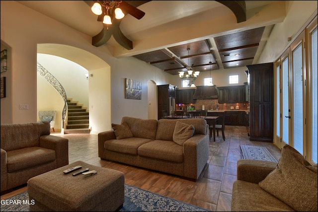 living room featuring coffered ceiling, beam ceiling, wood-type flooring, and ceiling fan with notable chandelier