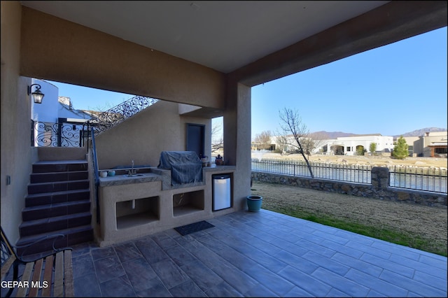 view of patio / terrace with a grill and exterior fireplace