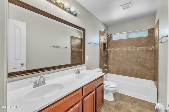 full bathroom featuring vanity, toilet, and tiled shower / bath