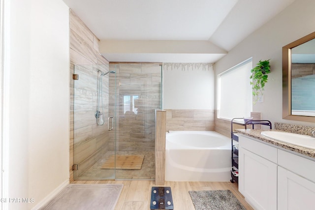 bathroom featuring vanity, separate shower and tub, and lofted ceiling