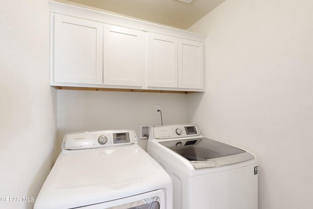 washroom featuring washer and clothes dryer and cabinets