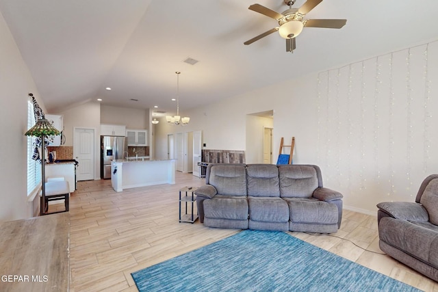 living room with lofted ceiling, ceiling fan with notable chandelier, and light hardwood / wood-style floors