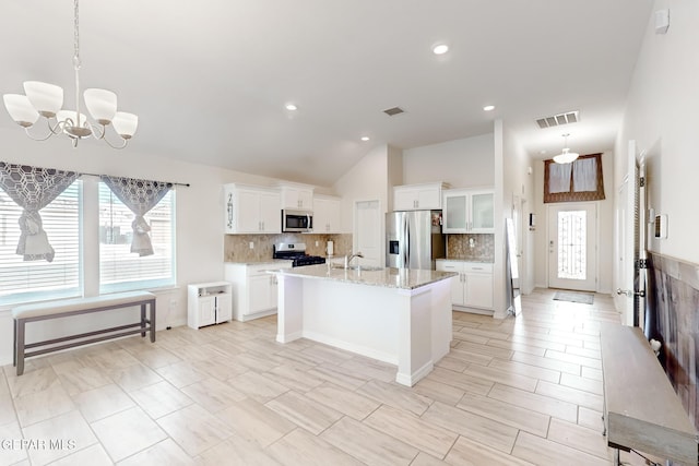 kitchen featuring sink, decorative light fixtures, appliances with stainless steel finishes, a kitchen island with sink, and white cabinets