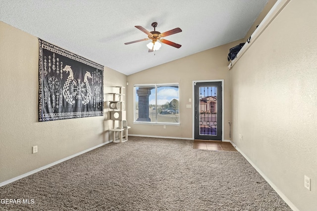 unfurnished room with ceiling fan, lofted ceiling, light colored carpet, and a textured ceiling