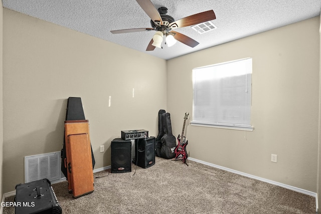 misc room featuring ceiling fan, carpet flooring, and a textured ceiling